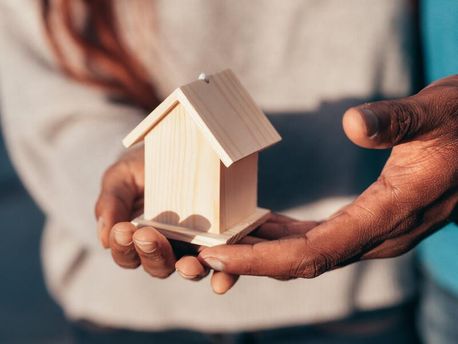 casa de madera en la mano de una persona